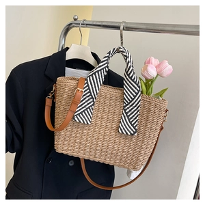 Détail du sac cabas en paille avec poignée en foulard à rayures et sangle en cuir