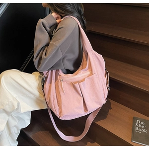 Detail of pink large-capacity nylon tote bag with functional pockets and wide strap