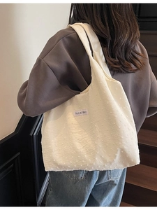 Women's minimalist white canvas tote bag with textured dots and shoulder strap
