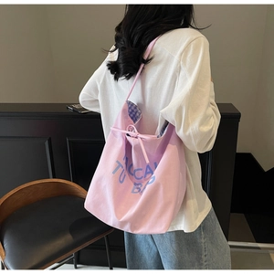 Détail du sac cabas en toile lilas avec lettrage bleu, cordon et doublure à carreaux