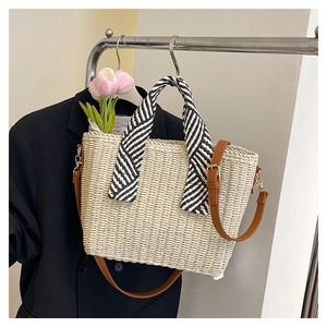 Détail du cabas en paille tissée avec poignée en foulard de soie et bandoulière en cuir