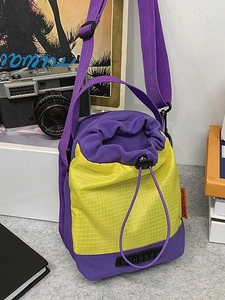 Contrast color drawstring bucket bag in purple and yellow with adjustable strap