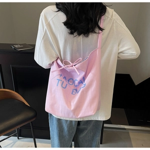Détail du sac fourre-tout en toile rose avec imprimé PAOCAI bleu et détail de nœud