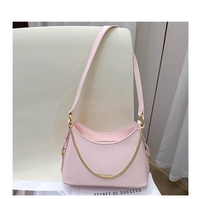 Close-up of pink glossy leather tote bag with elegant gold chain and zipper closure