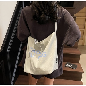Vue détaillée du grand sac cabas en toile avec imprimé TAO BAG bleu et cordon de serrage