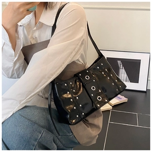 Détail du sac bandoulière en cuir verni noir avec clous argentés et style rétro Y2K