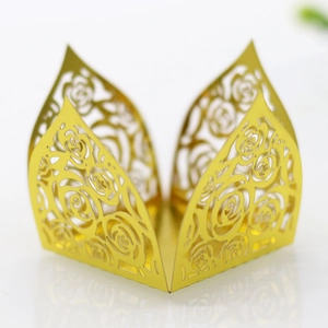 Macro detail of laser-cut gold rose pattern on hollowed chocolate truffle paper wrap