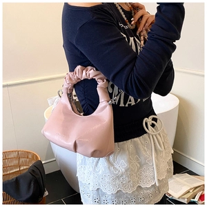 Détail du sac à main rose avec poignée froncée en nuage et silhouette en demi-lune chic