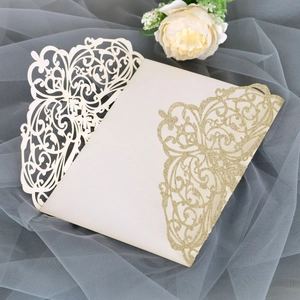 Macro detail of laser-cut wedding invitation featuring elegant European scrollwork and gold glitter