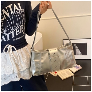 Détail du sac bandoulière argenté à rivets avec sangle à œillets de style punk