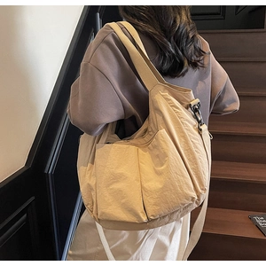 Detail view of khaki large capacity canvas tote bag with multi-pockets on model