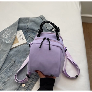Detail of light purple waterproof nylon backpack with decorative black and white cord handle