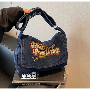 Detail of vintage denim tote bag with Lookin' Good Feeling embroidery and stars