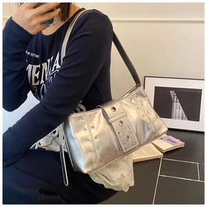 Vue détaillée d'un sac à main argenté avec rivets et œillets au style moto Y2K