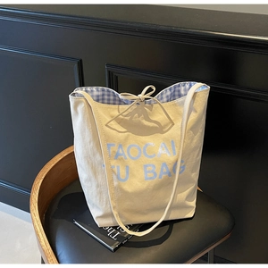 Détail d'un sac cabas en toile avec doublure bleue et fermeture par nœud élégant