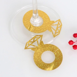 Primer plano de tarjetas de anillo de diamante doradas con purpurina para copas de boda