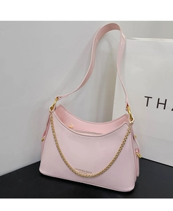 Detail of light pink patent leather shoulder bag with golden chain and logo lettering