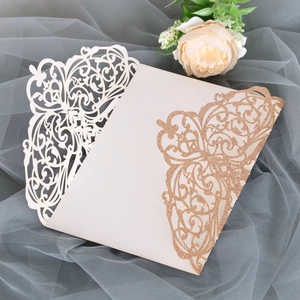 Detail of laser-cut wedding invitation with cream paper and rose gold glitter texture
