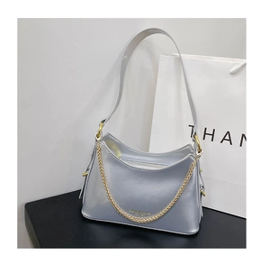 Close-up of metallic silver tote bag with golden chain and fashion leather logo