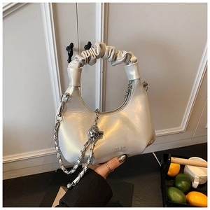 Détail du sac coquille argenté nacré avec poignée en forme de nuage et bandoulière