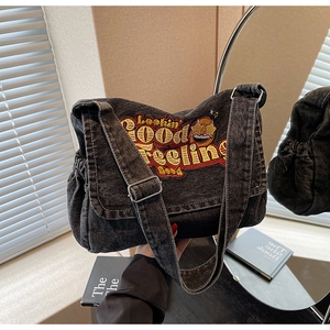 Close-up of vintage denim tote bag with colorful Lookin' Good Feeling Good embroidery