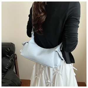 Vue latérale d'un sac à bandoulière bleu clair en croissant avec détails de laçage