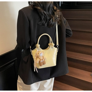 Yellow faux leather bucket bag with crocodile texture and cute plush bear charm