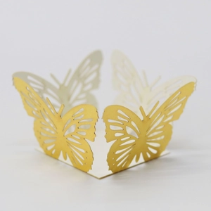 Detailed laser-cut golden butterfly cupcake wrapper with intricate pearlescent hollow design
