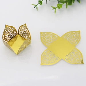 Flat-lay showing laser-cut gold hollow rose candy boxes in folded and flat states