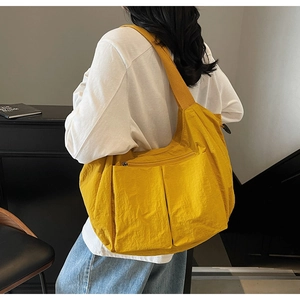 Detailed view of yellow canvas messenger bag with large front pockets and wide strap
