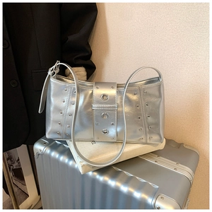 Détails de rivets argentés et ceinture à œillets sur un sac hobo en similicuir perlé