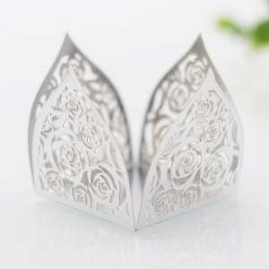 Detail of white laser-cut cupcake wrapper with elegant hollowed-out rose floral patterns
