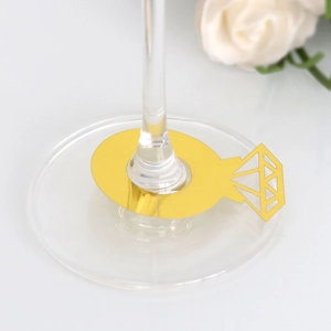 Detalle de tarjetas de mesa doradas con forma de anillo de diamante en copa