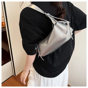Détail d'un sac à bandoulière argenté métallisé avec forme rectangulaire souple et cuir fin