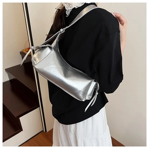 Détail d'un sac à bandoulière cylindrique argent métallisé avec une texture brillante