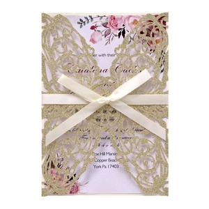 Laser-cut butterfly wedding invitation in gold glitter paper with white ribbon bow