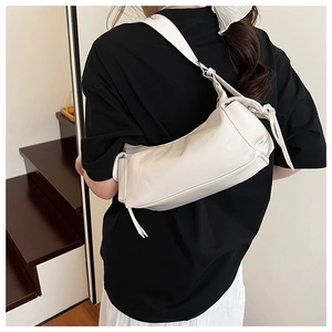 Détail du sac bandoulière blanc minimaliste en forme de croissant sur modèle