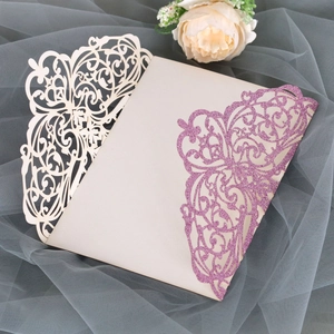 Detailed laser-cut wedding invitation featuring pink glitter wing and floral patterns