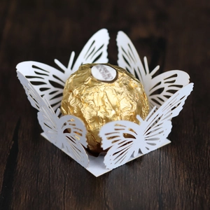 Detail of white laser-cut butterfly lace paper truffle holder for wedding sweets