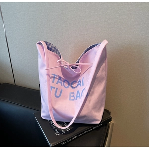 Détail du sac cabas en toile rose avec lettrage bleu et doublure à carreaux vichy