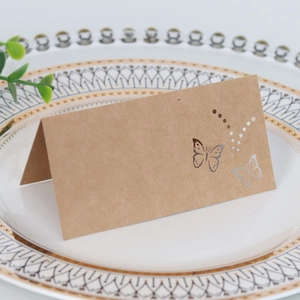 Laser-cut butterfly design on rustic brown kraft paper place cards for wedding tables