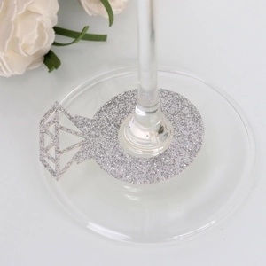 Close-up of silver glitter diamond ring shape place cards on glass base
