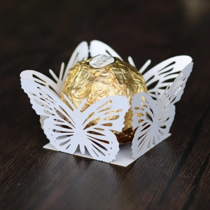 Detail of laser-cut white butterfly paper favor box for chocolates and party desserts