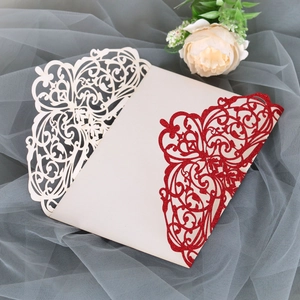 Close-up of laser-cut floral wedding invitation cover with elegant red glitter details