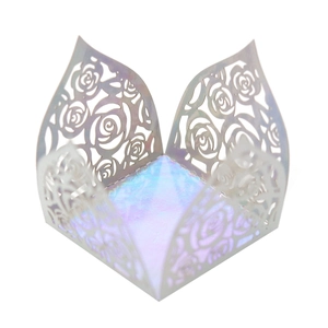 Macro detail of white laser-cut rose hollow paper gift box with iridescent pearl finish