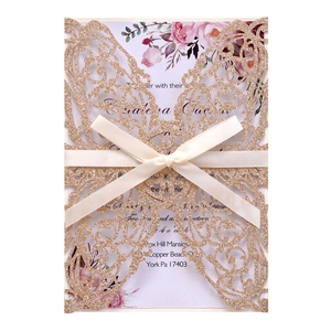 Detail of laser-cut butterfly invitation with glitter finish and satin ribbon bow