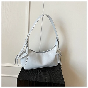 Détail du sac sous le bras en cuir bleu clair brillant avec cordons décoratifs