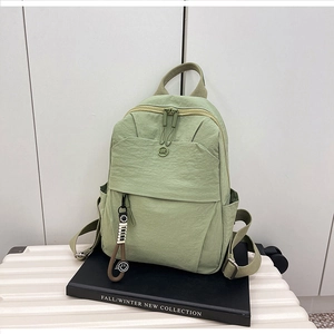 Detail of Morandi green nylon backpack with textured fabric and smiley face charm