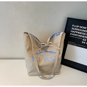 Détail du sac cabas en toile montrant l'imprimé bleu et la doublure à carreaux Gingham