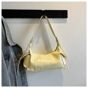 Vue détaillée du sac bandoulière en cuir jaune crème avec détails de sangles décoratives